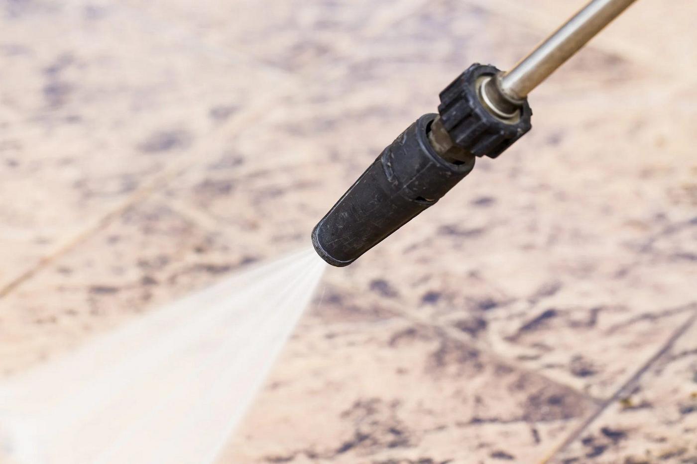 Pressure washer lance cleaning a paved patio